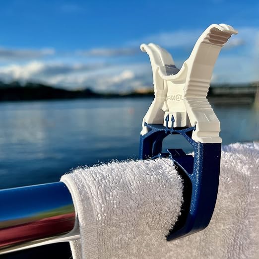 FixClip in actie op een boot, stevig een handdoek vasthoudend aan een railing, ideaal voor wind en water.