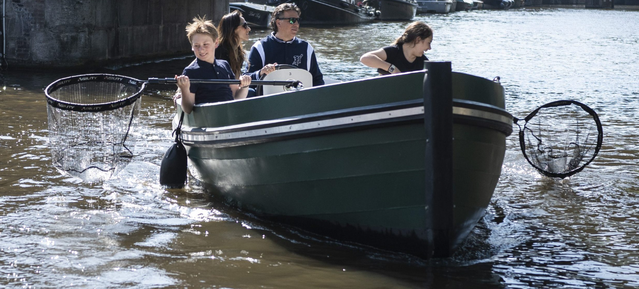 4 personen op boot met schepnet 